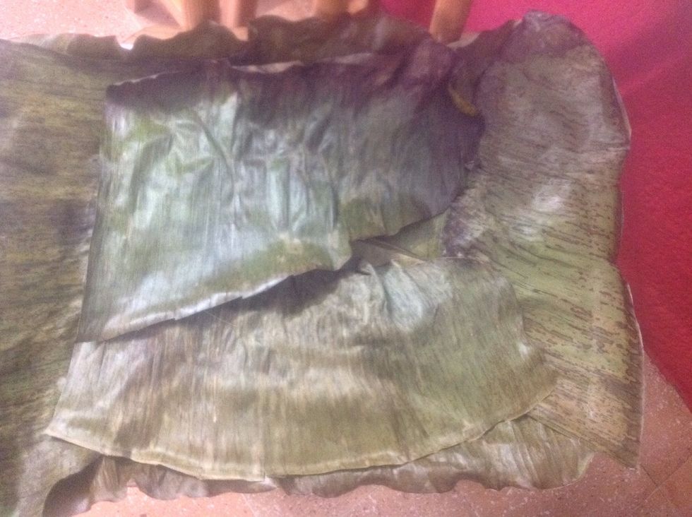 Fully cover the bottom of your baking sheet with banana leaves. Let leaves stand out from borders about 2 inches. You can cut out the center part of leaves, so you can bend them better.