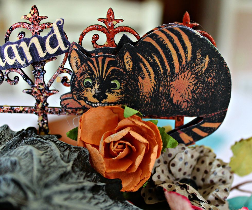 Fussy cut a cat image from the pattern paper; adhere to gate along with more flowers, berries, etc.