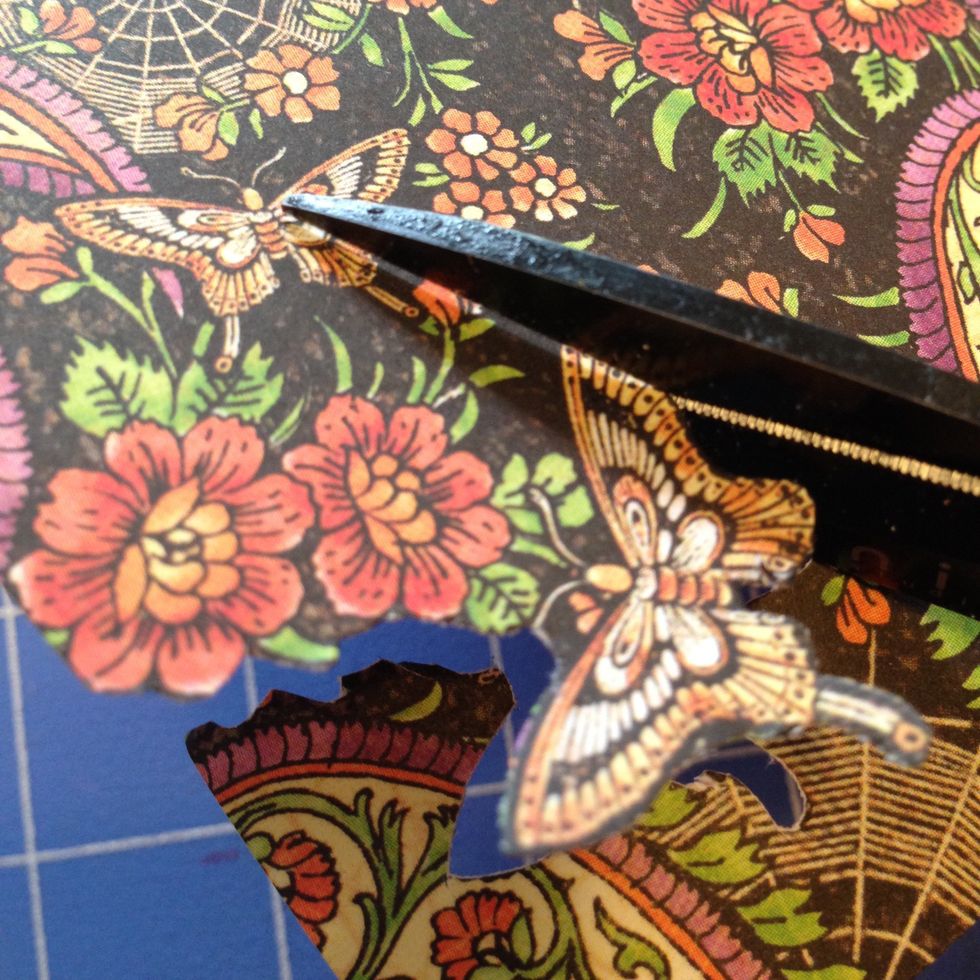 Fussy cut a few orange flowers and a butterfly,  and anything else on the paper that you want inside the doily.