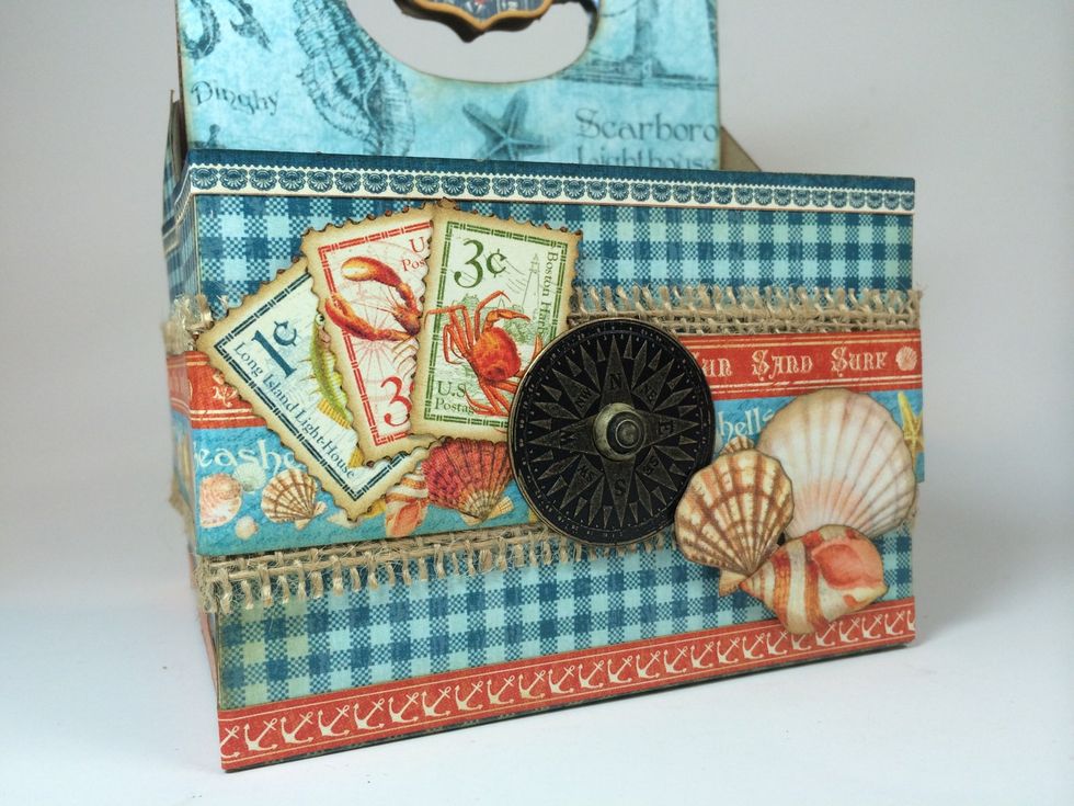 Fussy cut elements from By The Sea signature page and adhere in clusters. Layer metal compass and brad with strong adhesive.