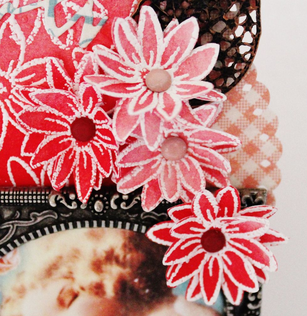 Fussy cut embossed and ink flowers. Layer together with small brads. Adhere to top of tag with metal leaf charm.