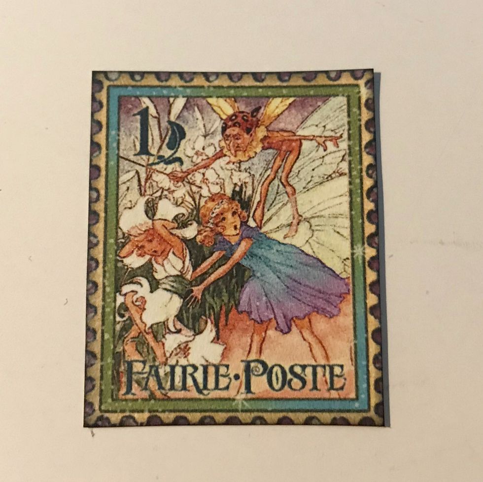 Fussy cut one more stamp from the border paper. Ink the edges of the stamp using Photogenic Ink and a blending tool.