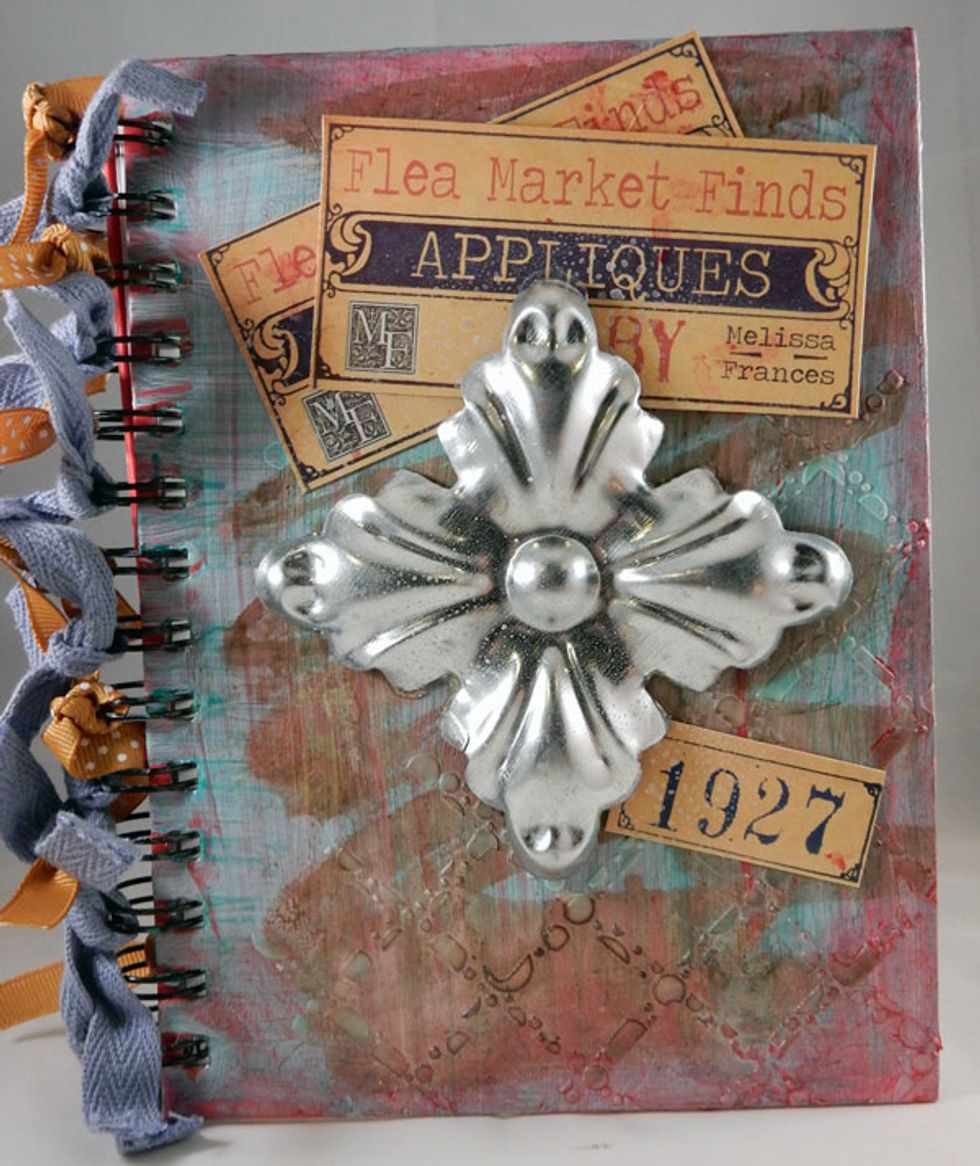 Fussy cut packaging and add the pieces to decorate the front cover. Add ribbon to the spirals.