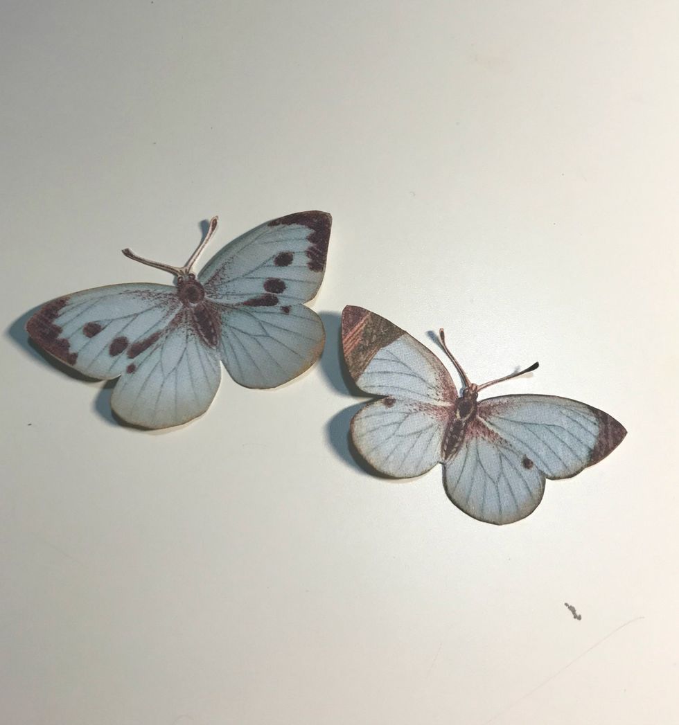 Fussy cut two butterflies from the patterned paper pieces. Ink the edges of the butterflies using Vintage Photo Distress Ink.