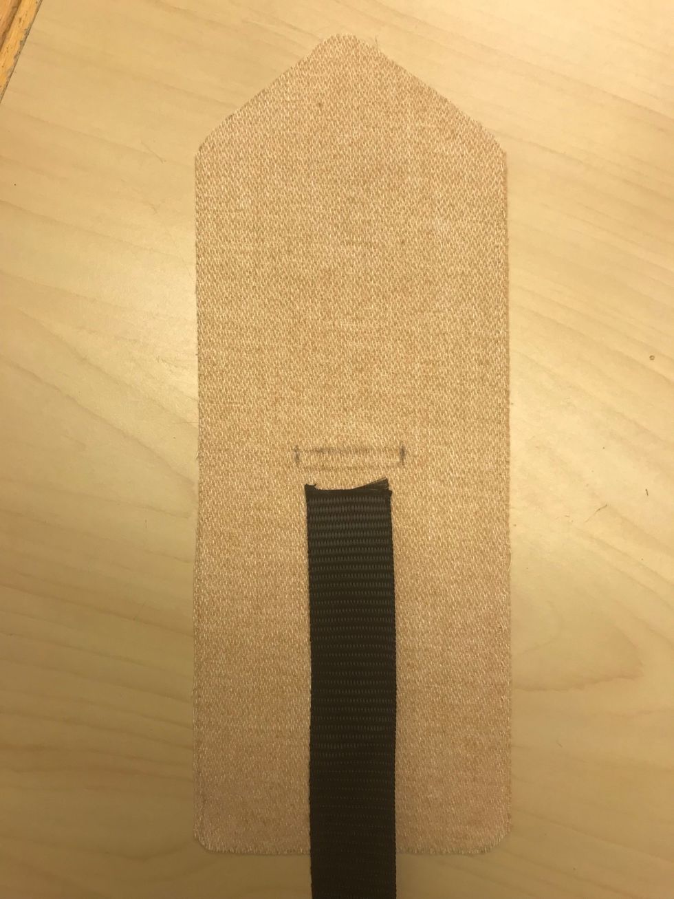 G\u00f6r ett h\u00e5l, ca 12 cm upp p\u00e5 de l\u00e4ngsta tygbitarna. G\u00f6r h\u00e5let lika brett som bandet