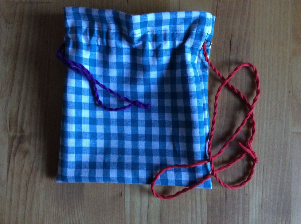 G\u00f6r likadant med andra snodden men tr\u00e4 in den fr\u00e5n p\u00e5sens andra sida. Knyt ihop \u00e4ndarna. Klipp av 1 cm fr\u00e5n knuten.