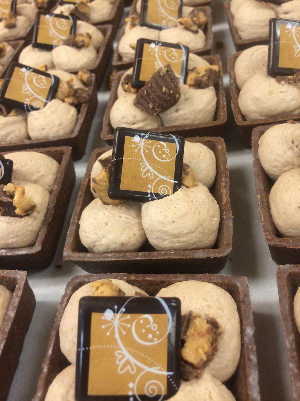 Garnished with chopped peanut butter cups and a decorative chocolate plaque.