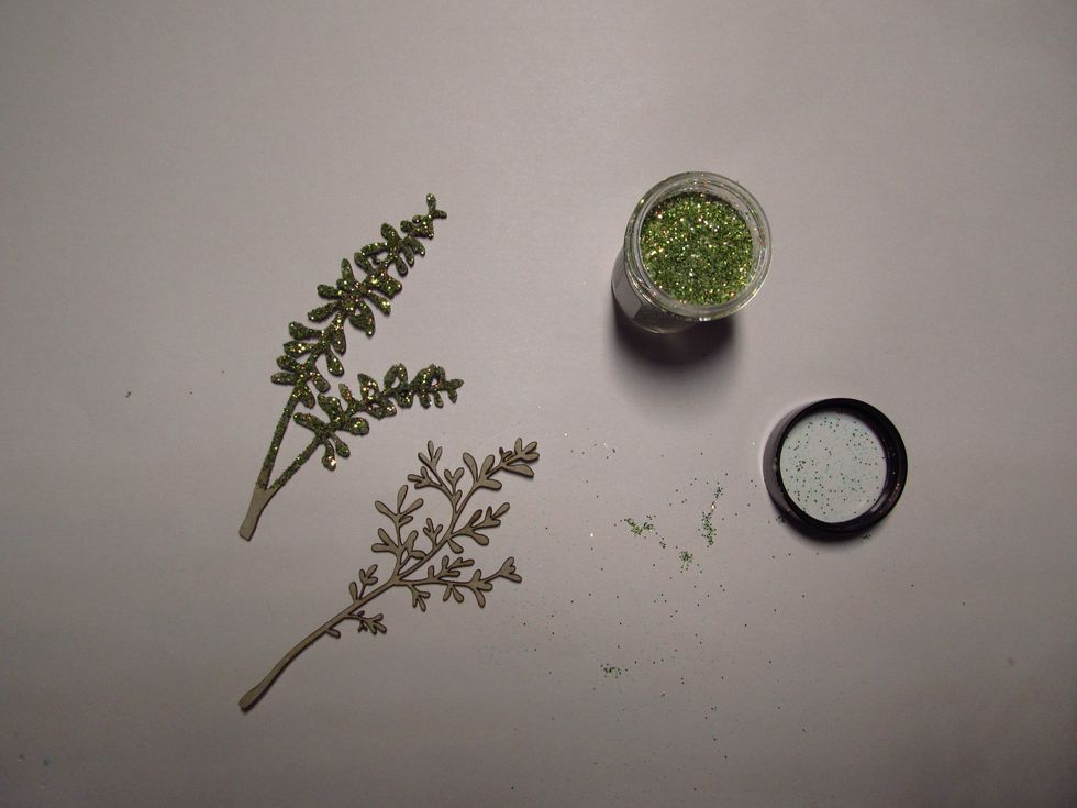 Gather a couple of pieces of the chipboard stems from the kit along with the glitter and your favorite glue that dries clear. Add the glue to the stems and sprinkle with the glitter.