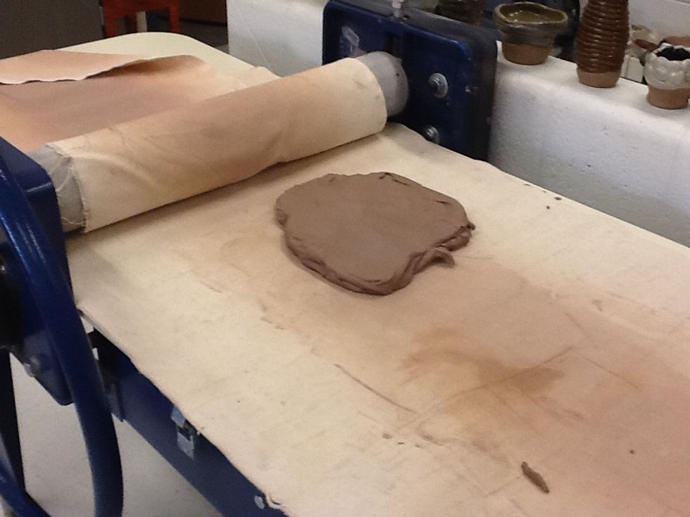 Gather a large amount of clay that will be rolled into a flat slab. Be sure you don't roll your clay too thin or too thick. Before using a slab roller flatten your clay so it fits into the roller.
