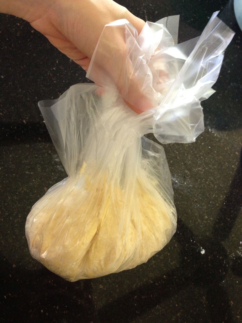Gather all 4 corners of bag and twist top tightly like this! Then - don't doubt this step or skip on it - squash together the pastry so it no longer crumbles. Do this in a minute so it doesn't melt!!