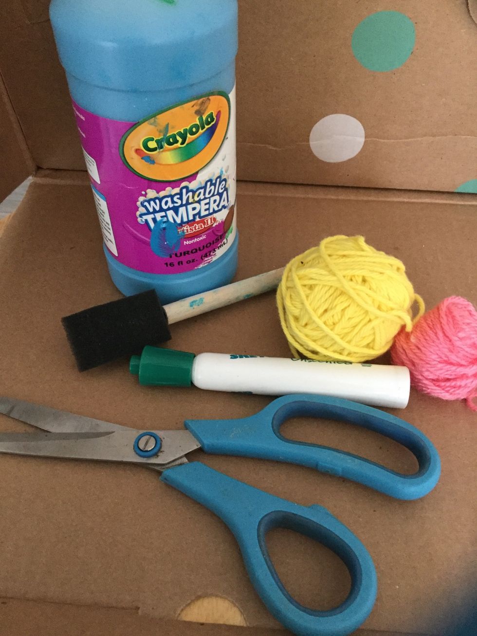 Gather all your supplies: cardboard, scissors, paint, foam brush, 2 balls of different colored yarn, and a marker