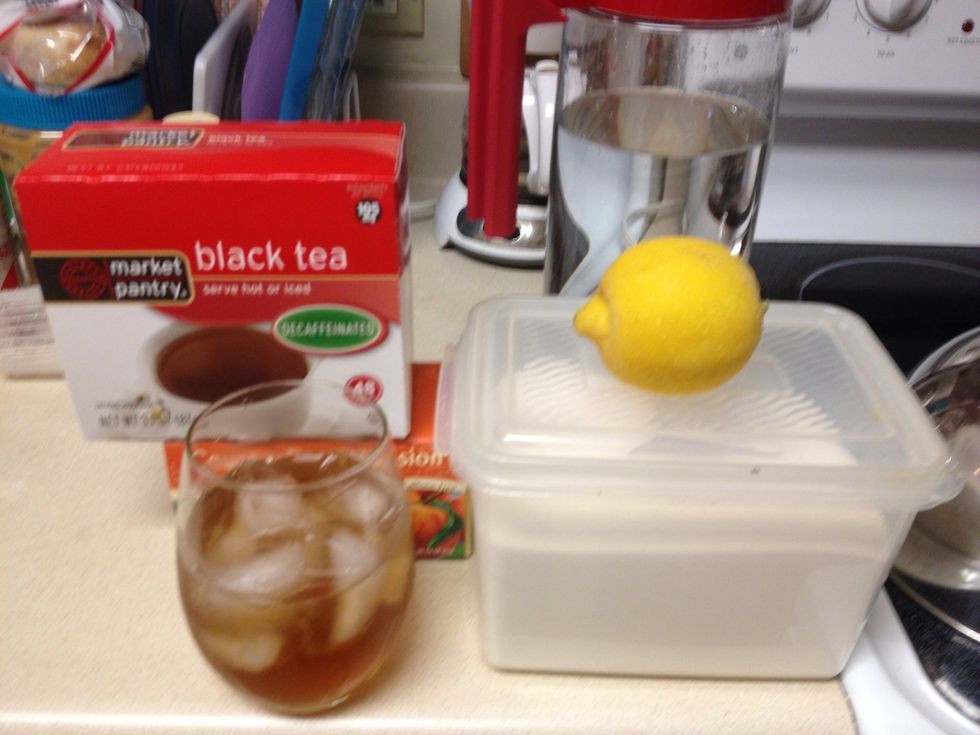 Gather all your supplies. You will need 4 teabags, sugar, 3 tablespoons of peach flavored syrup, a teakettle, and a quarter of a lemon.