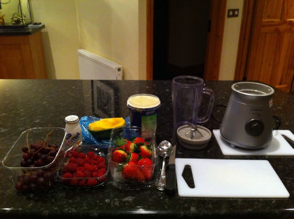 Gather equipment, you will need a blender, chopping board, spoon, knife. Ingredients includes strawberries, raspberries, grapes, mango, yogurt, yogurt drink, ice and honey :)