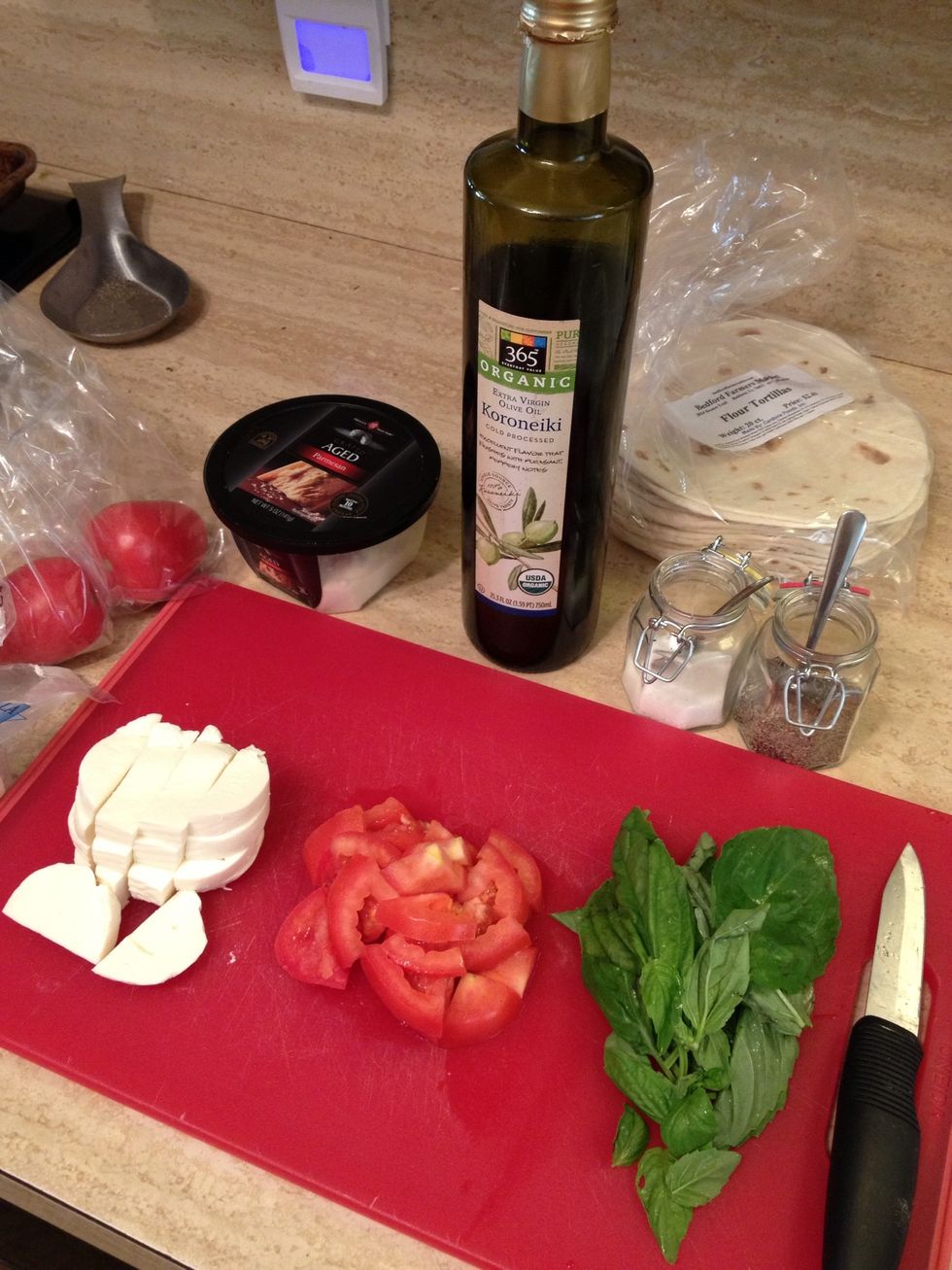 Gather ingredients. Rinse tomato and basil, then chop tomato and cut up cheese. Tear basil leaves off stems(But don't tear the leaves apart until right after the pizzas are done otherwise they brown)