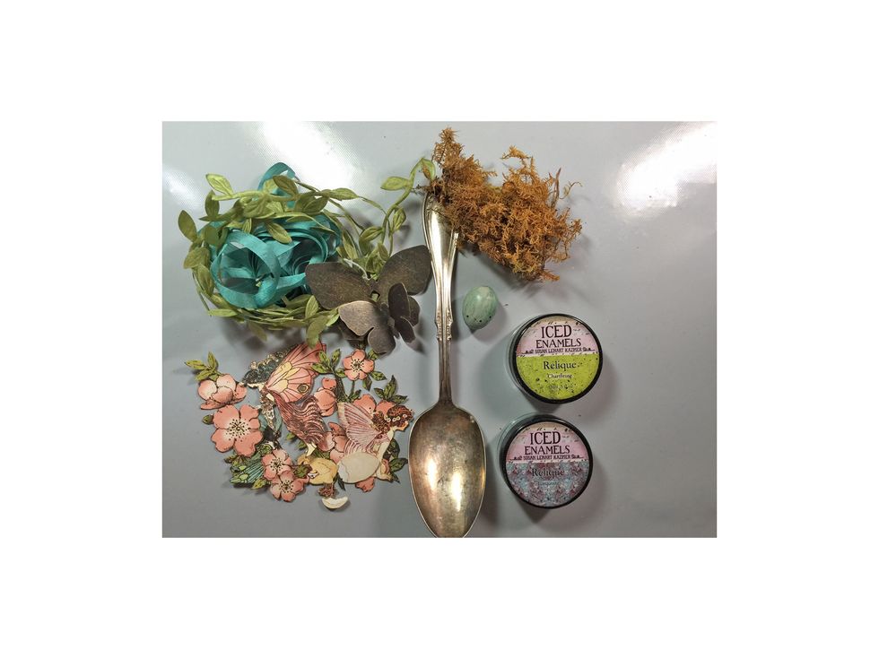 Gather supplies together for your project. You'll need some embossing powder, versa mark ink, ribbon, fussy cut images from Graphic 45, metal butterflies, moss, egg and of course a spoon.
