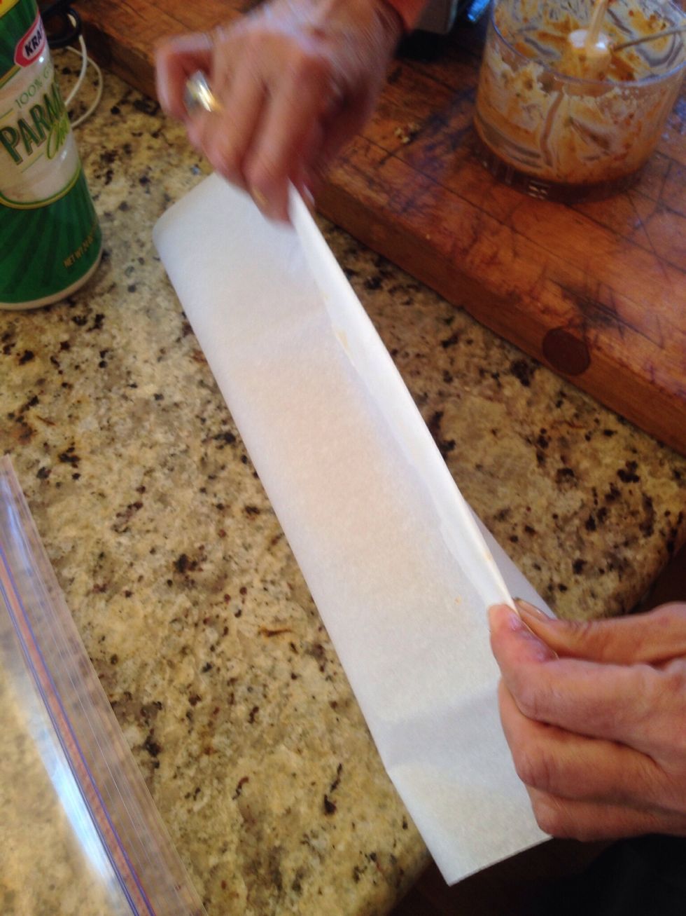 Gather the ends of the parchment and fold the edges over and over again Folding and creasing until it tightens around the butter.