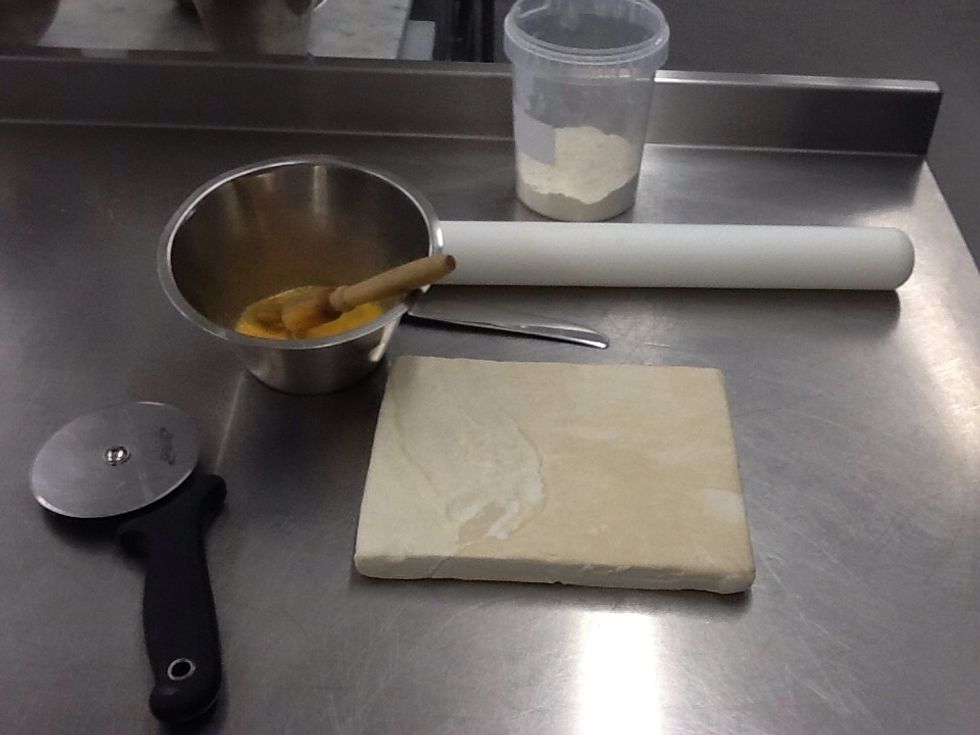 Gather your ingredients and equipment. Puff pastry, flour for dusting, egg wash, rolling pin, pastry wheel (pizza cutter) or knife.