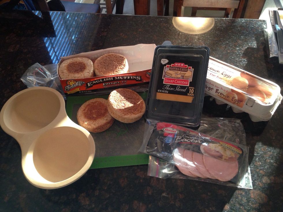 Gather your ingredients... I like to use Ezekiel 4:9 English Muffins, Sliced cheddar cheese, Eggs, Canadian Bacon and butter.