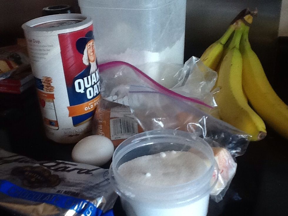 Gather your ingredients; mashed bananas, brown sugar, butter, granulated sugar, vanilla extract, egg, old-fashioned oats, salt, and chocolate chips.