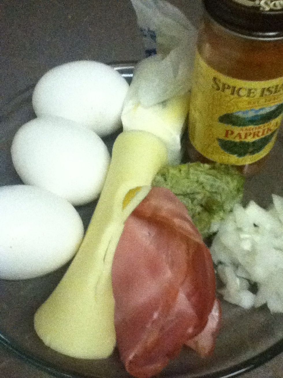 Gather your ingredients together. Heat and oil your skillet. Crack your eggs into a bowl and scramble, add pesto sauce and onions. Pour mixture in to your hot skillet.
