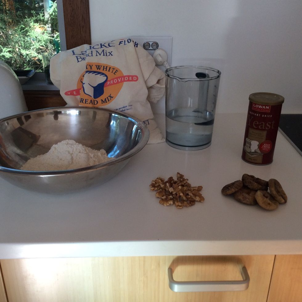 Gather your ingredients. You will need: a large bowl, a spoon, a jug, an apron, oven mitts and a bread tin. For ingredients check 'supplies'