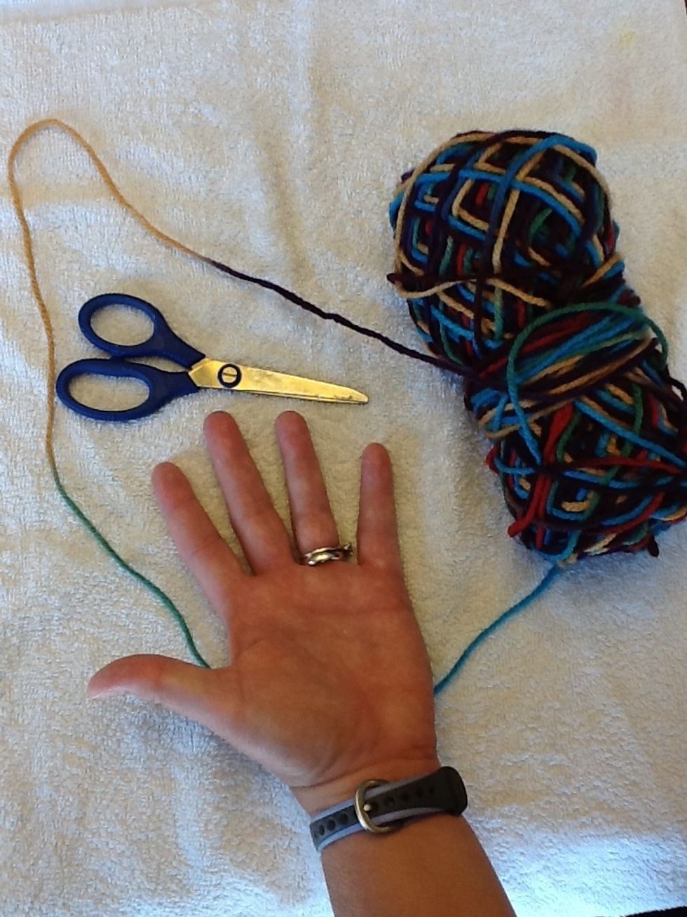 Gather your supplies; yarn, scissors and your hand.