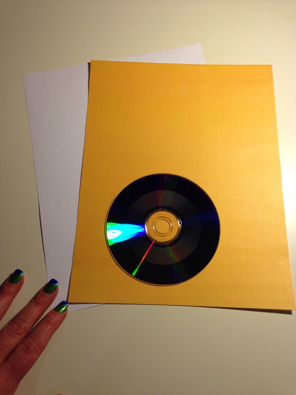 Gather your supplies. You need just a sheet of paper and a disc. I'm using an 8.5" x 11" sheet of craft paper, but a sheet of basic printer paper would work just fine.