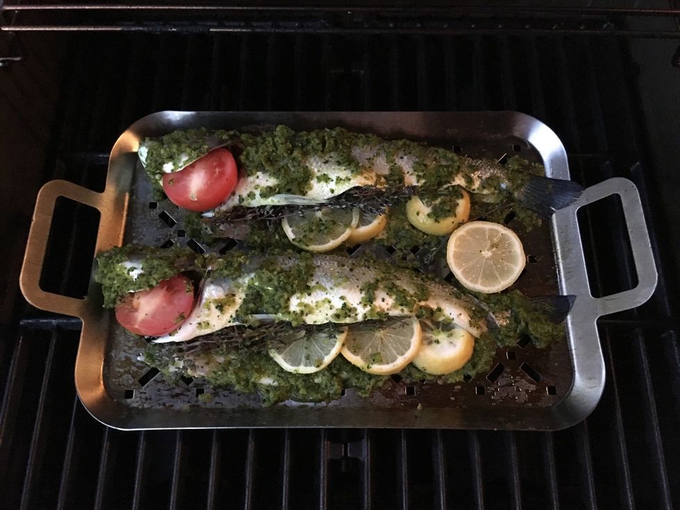 Generously rub the paste on the fish, both inside and outside. Stuff the fish with thyme sprigs, lemon slices and tomato half as shown in the picture.