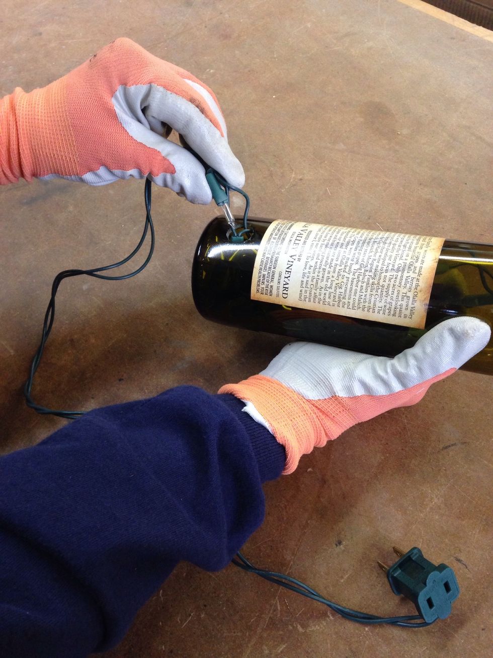 Gently pinch the wires and feed the lights through the hole.