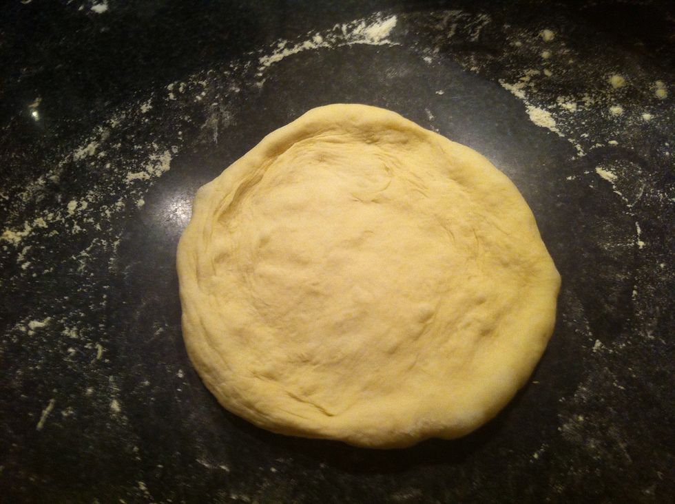 Gently press the dough from the center out stopping about 1/2 inch from the edge. This part is rather tricky. Then gently pick it up and stretch it around the edge. Be very careful and try not to tear