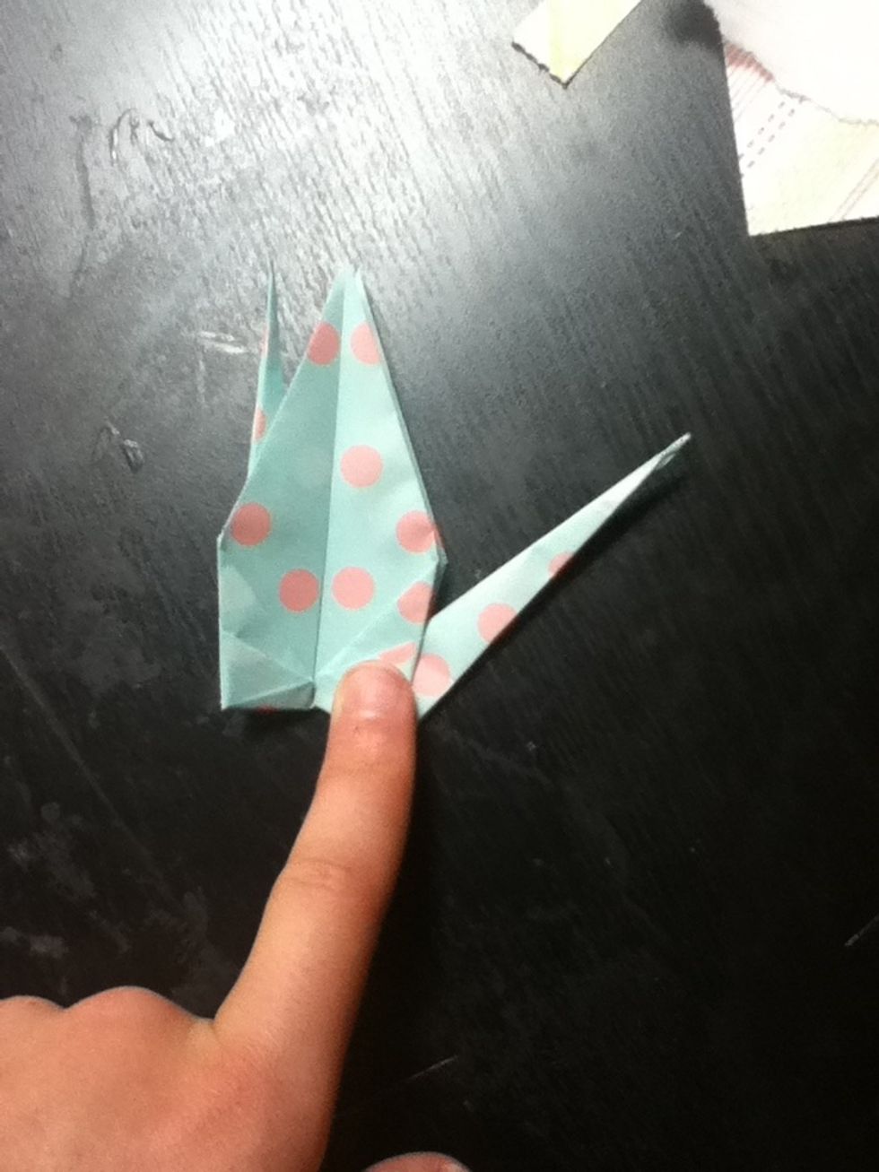 Gently pull one of your long strips outward. Then, push firmly where my finger is to crease it in place.