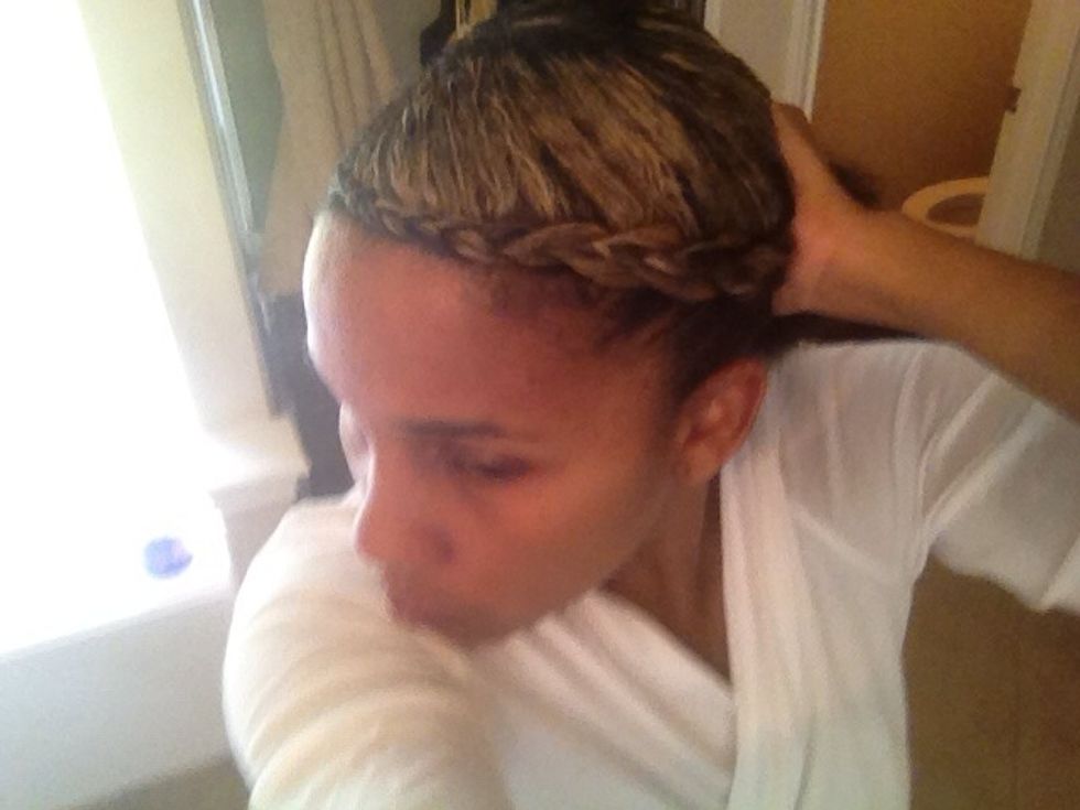 Gently pull the goddess braid and any unbraided hair back into a ponytail position. Smooth any loose or fly-away hairs down with a little EcoStyler gel and your hand.