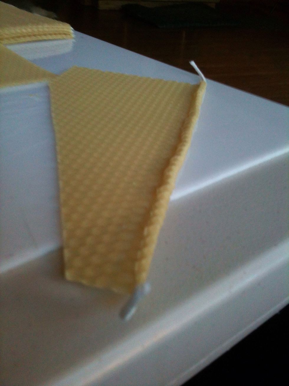 Gently push up the bottom edge of the wax and slowly roll it over the wick one time,then stop.