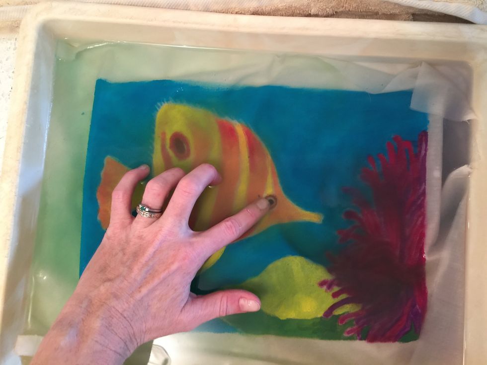 Gently rub off all of the glue and excess tempera paint. When you are sure that all of the glue is gone, blot it dry between two towels.