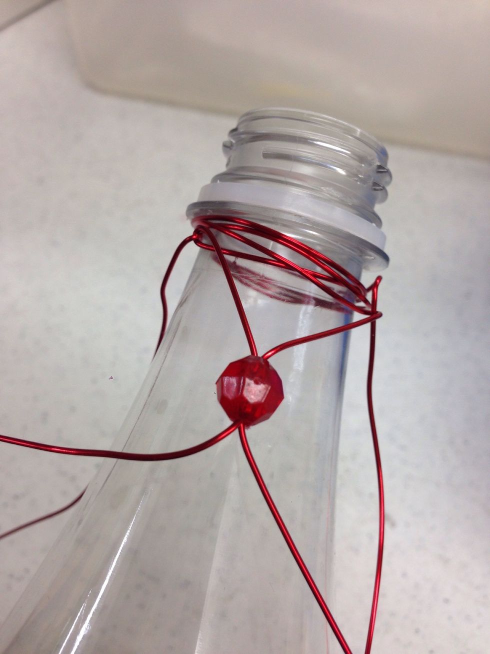 Gently spread the two wires apart to keep the bead in place.