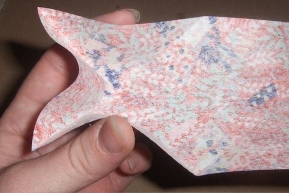Gently squish between the folds on the left side, as shown.