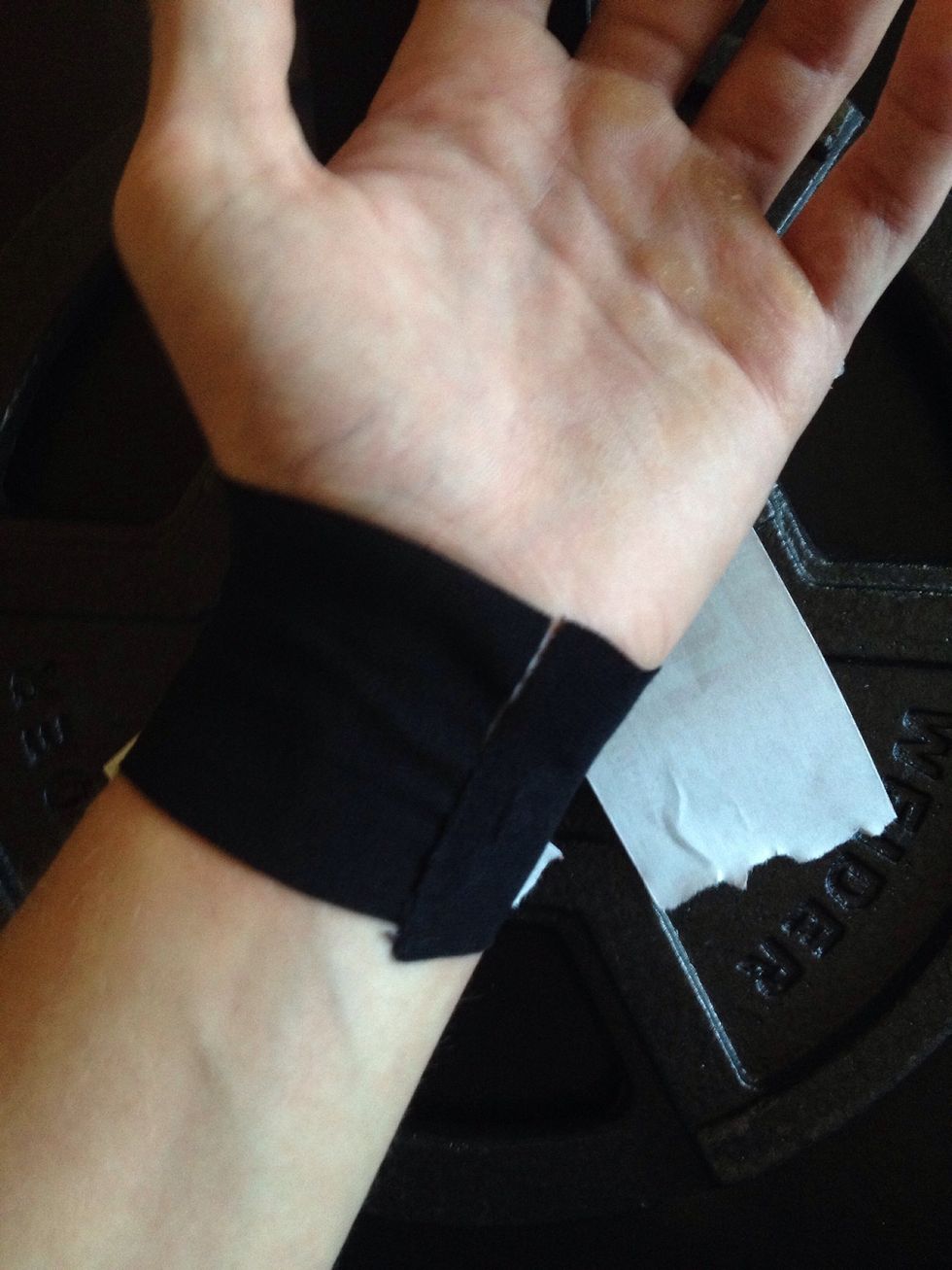 Gently stretch the tape around the circumference of your wrist, pulling back the paper and pressing the adhesive to your skin as you go. Be sure the edges are close but do not overlap.