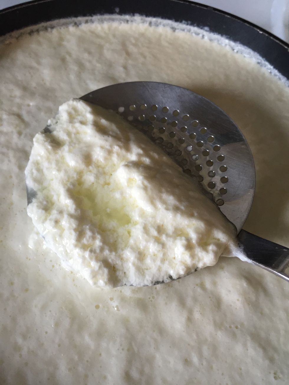 Gently, use the spoon to scoop the curds out of the liquid. The slower you move, the fewer curds will break. Small pieces will not form larger curds and are hard to remove. You'll lose some yield.