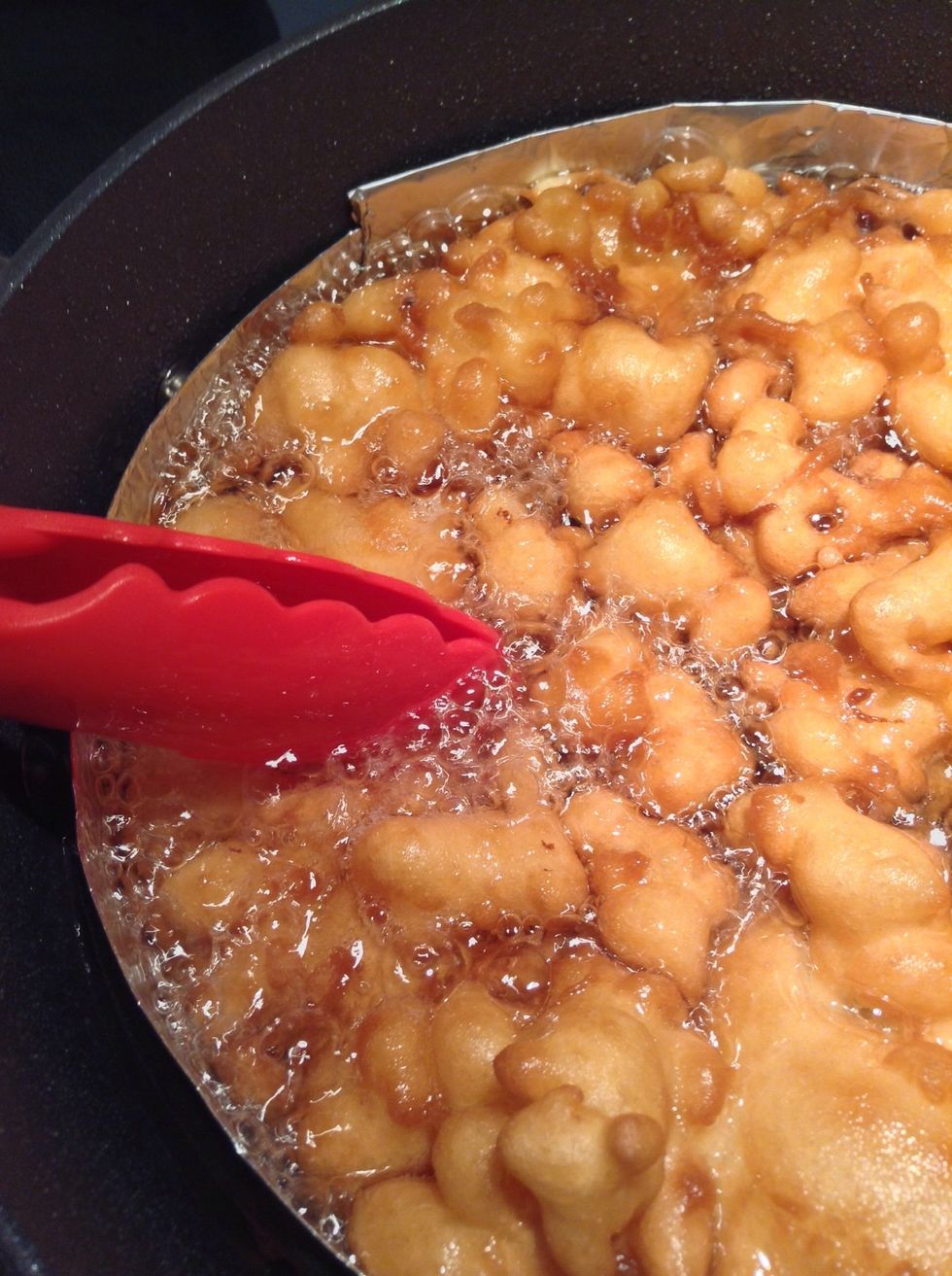 Gently with your tongs press down the top of the funnel cake. This allows the oil to get on top of the funnel cake as well. You won't have to do this constantly but every minute or so.