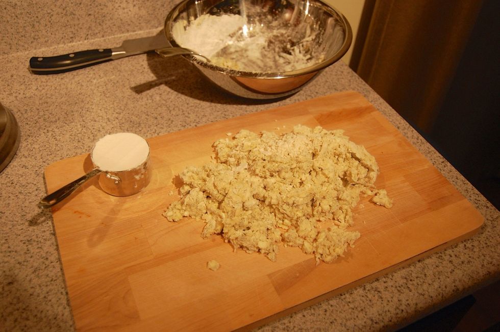Get 1/2 cup of flour, sprinkle some of it on dough board. Then place dough mixture on top of flour.
