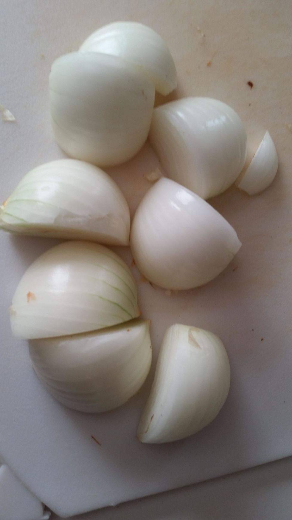 Get 2 medium brown or white onions and cut them into quarters. Or in half, then in half again. Set aside.