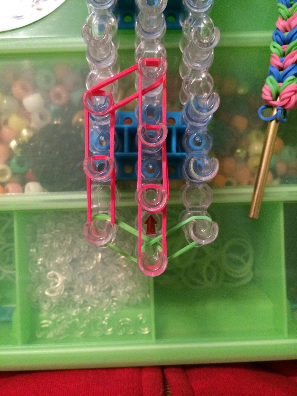 Get 2 more red bands and place them on the third and fourth pegs on the center row.