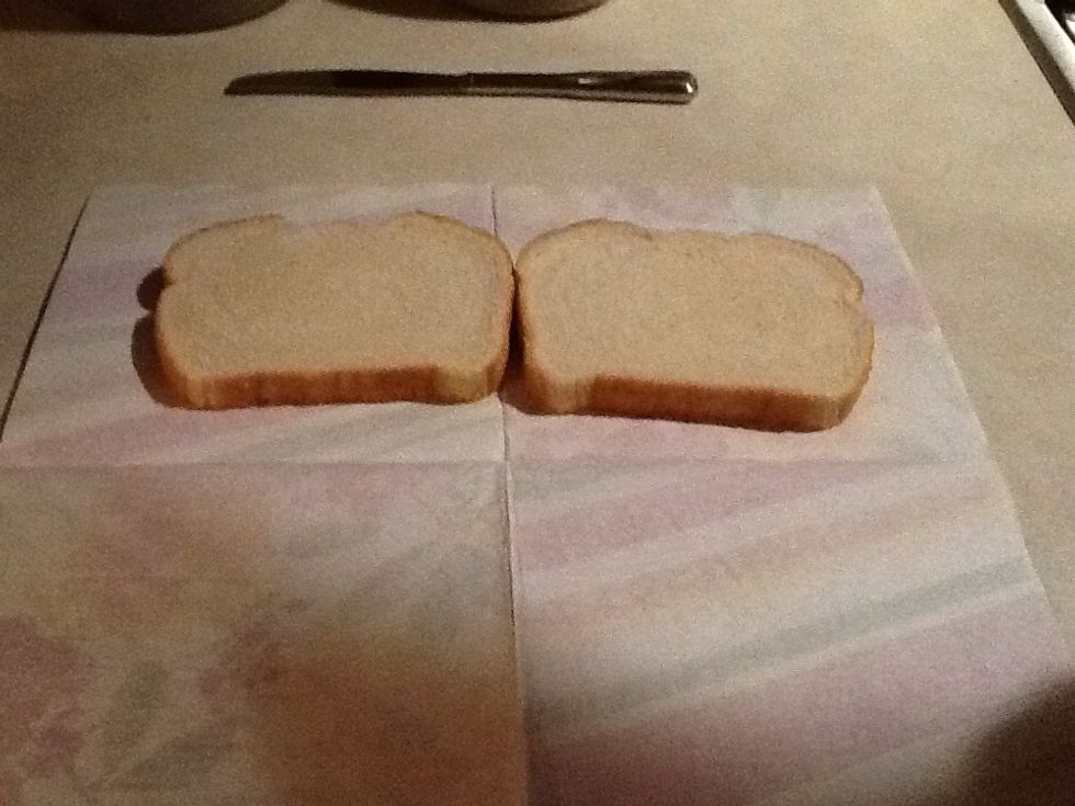 Get 2 slices of bread out, and lay them on a plate or napkin.
