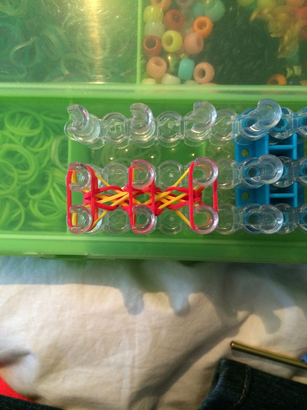 Get 3 red bands and place them across. Push them down.