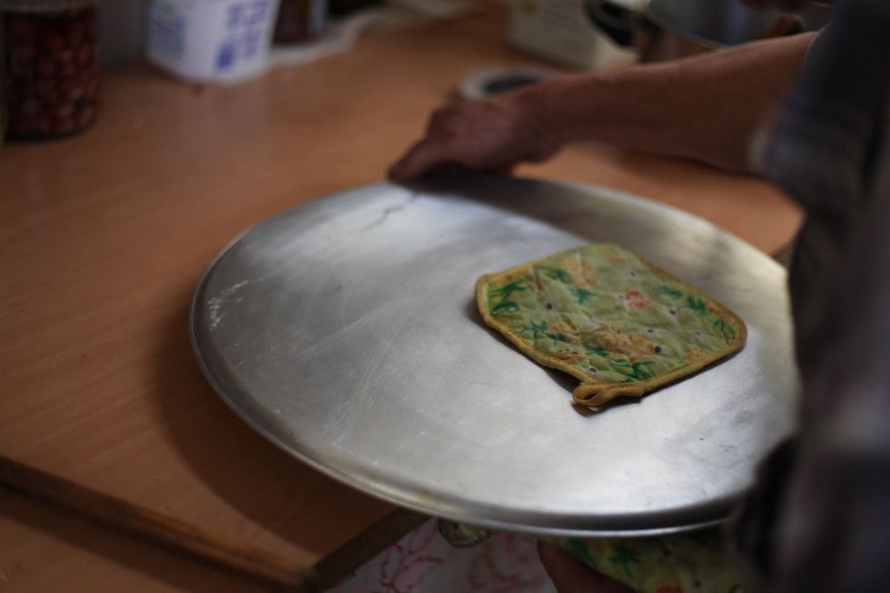 Get a bigger flat tray cover the small tray and flip it.