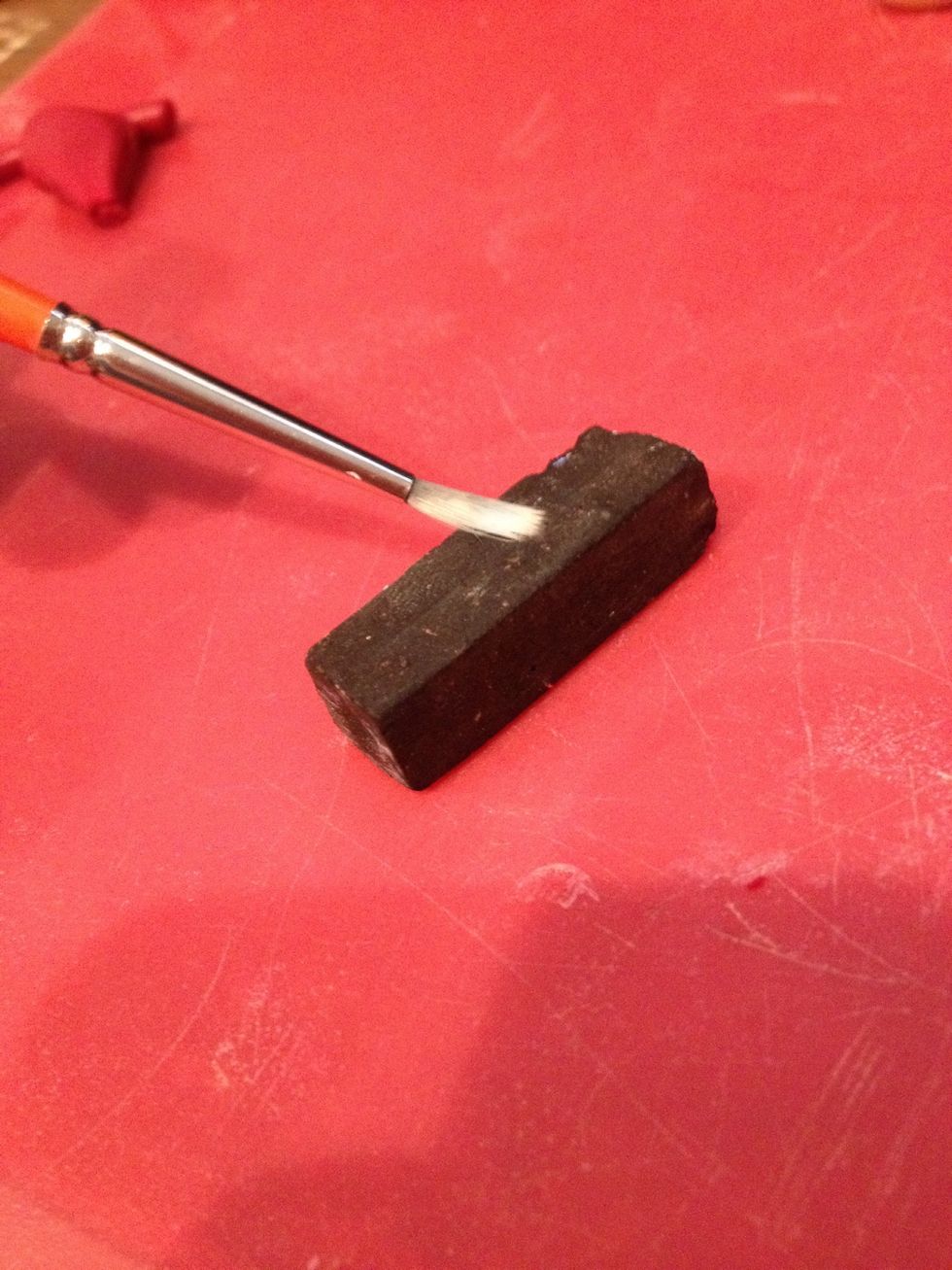 Get a black chalk pastel and load a brush