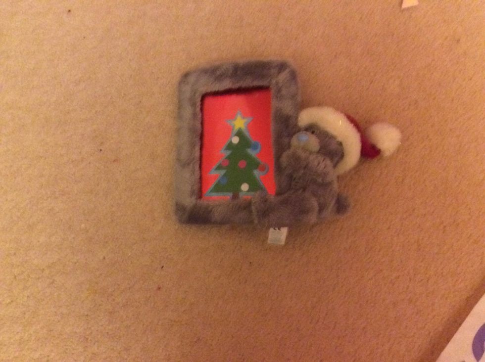 Get a Christmassy photo frame, Christmassy sticker and a piece of card. Trim the card down to size, put the sticker on, and add it to the Christmassy frame!