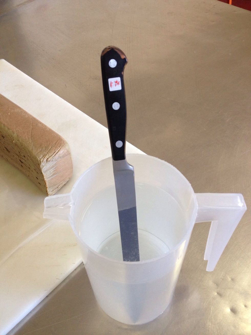 Get a long straight edged knife and place in really hot water