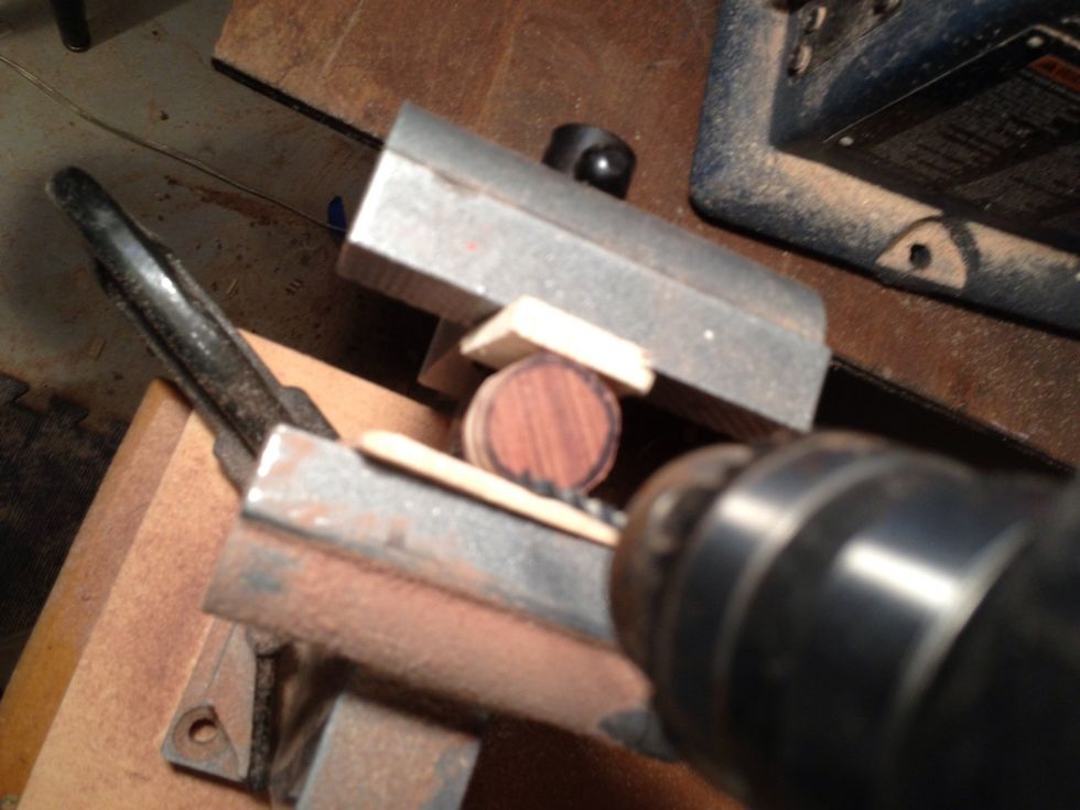 Get a small sharp drill bit go down the middle.