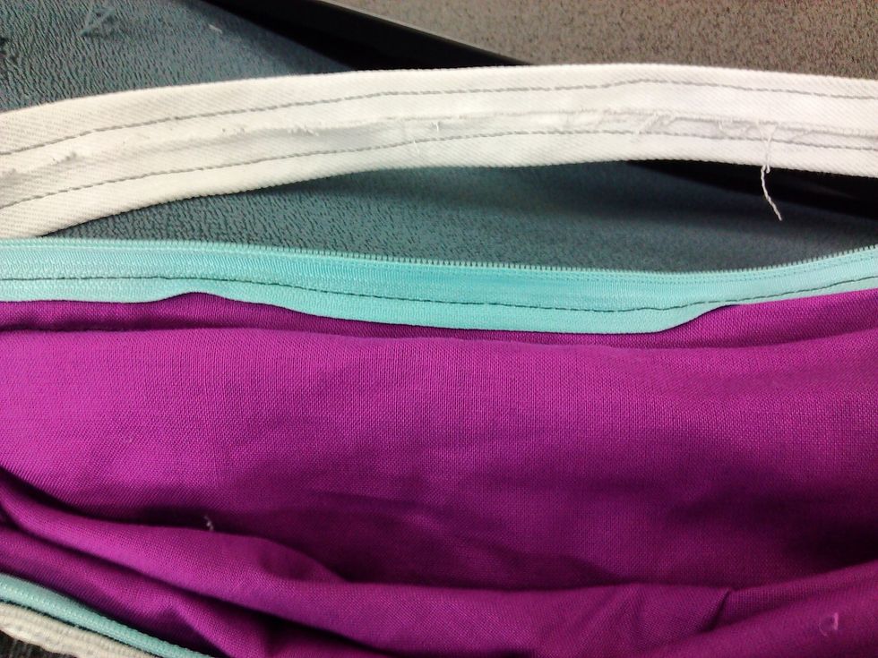 Get a zip the right that is the right size for your bag and unzip it so you can sew both sides along the bag (if you pin it first it will make it easier to sew)